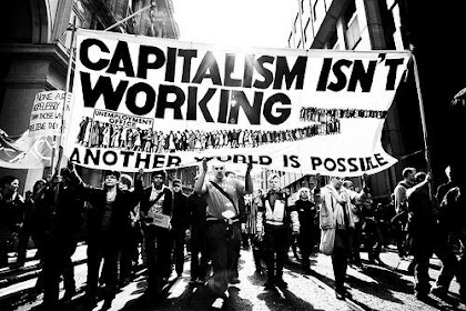 Marchers with banner, "Capitalism Isn't Working"